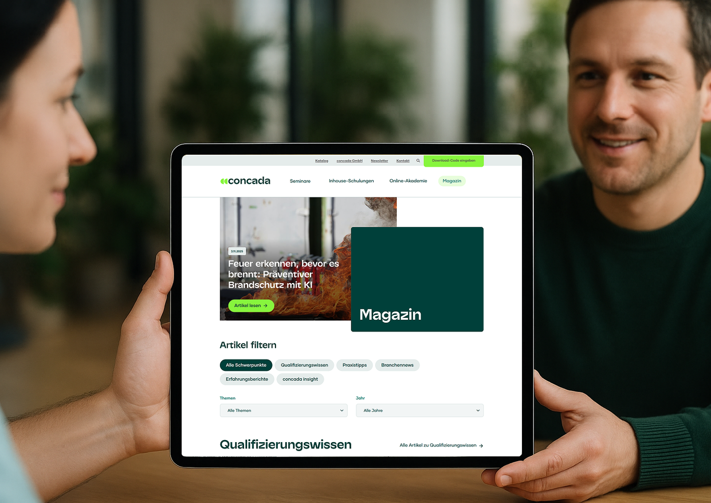 Zwei Personen betrachten auf einem Tablet die Website von concada mit dem Magazin.