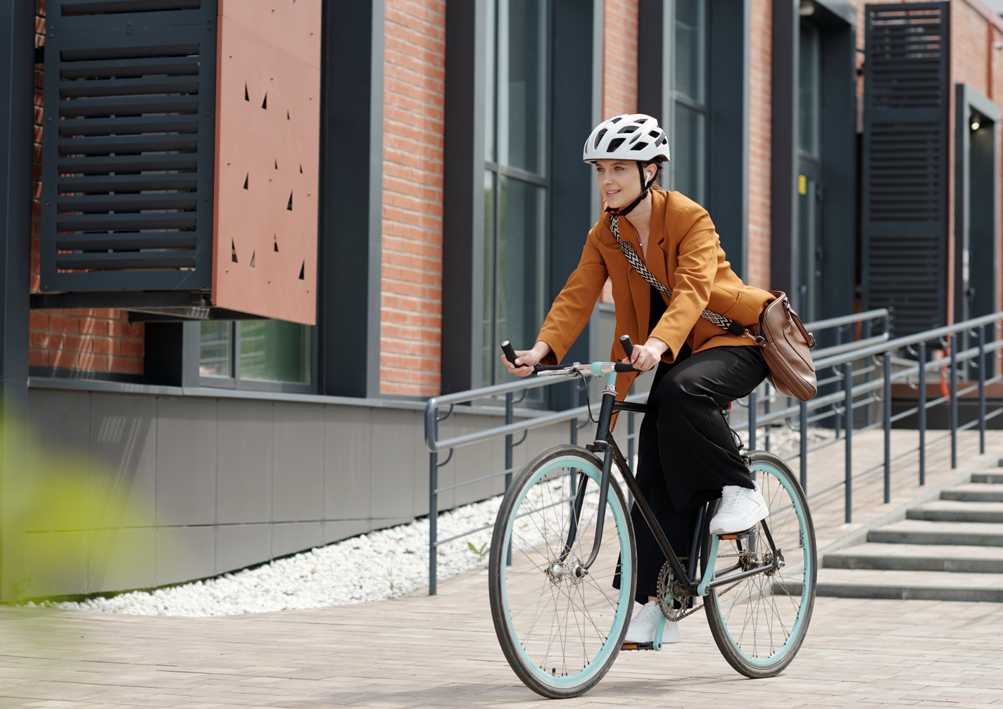 Eine Frau mit weißem Helm fährt ein schwarzes Fahrrad