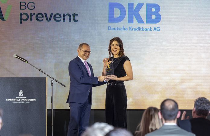 Prof. Dr. Thomas Auhuber (CEO BG prevent) übergibt den Pokal an Anja Speer (DKB). (© EUPD/Wenski)