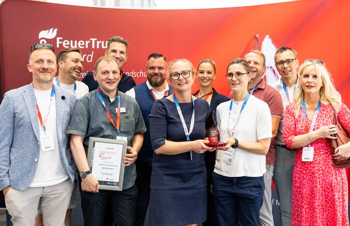 Teamfoto bei Übergabe des Awards vom FeuerTrutz 2025 vor gebrandeter Wand.
